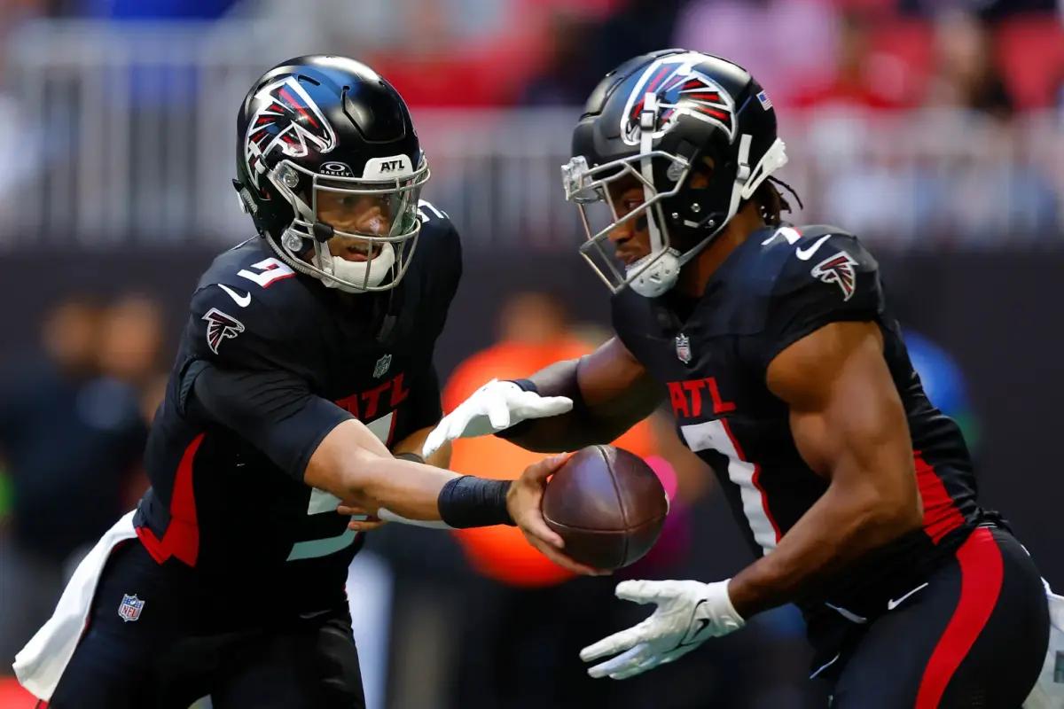 Atlanta Falcons quarterback Desmond Ridder hands off to running back Bijan Robinson.